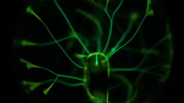 A close-up of the plasma ball coil during operation. The color of the electric rays created by the coil is a shade of green.