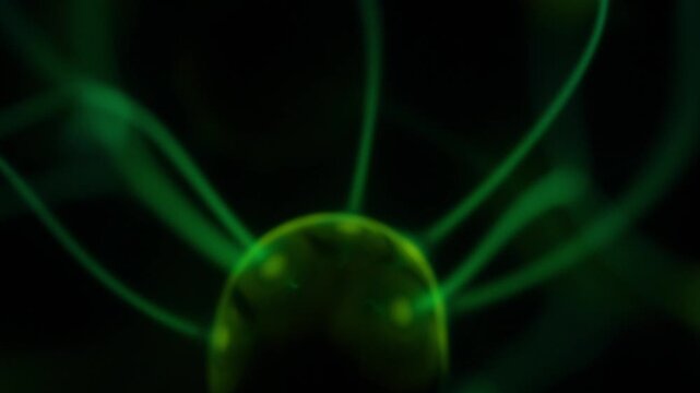 A close-up of the plasma ball coil during operation. The color of the electric rays created by the coil is a shade of green.