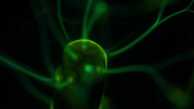 A close-up of the plasma ball coil during operation. The color of the electric rays created by the coil is a shade of green.