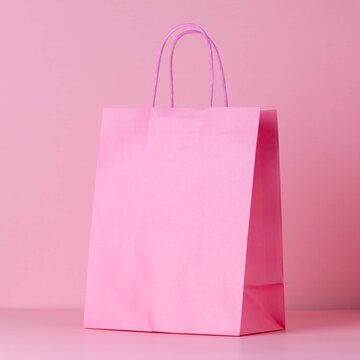 Pink, paper shopping bag package on pink background, blank copy space for text advertisement for discount or sales concept. Side view