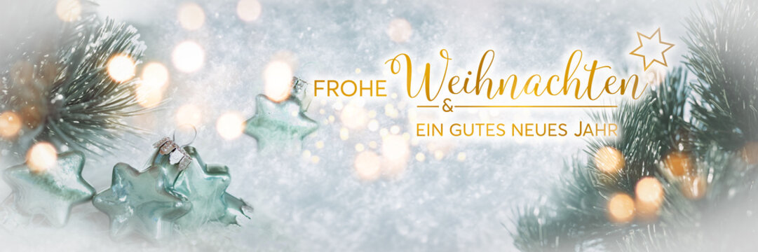 Wonderful winter background image with frosted pine branches. Poinsettias with festive golden bokeh lights in snow. Perfect for a german christmas greeting card.