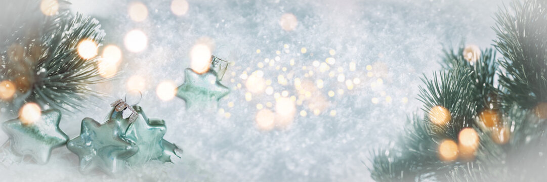 Wonderful winter background image with frosted pine branches. Poinsettias with festive golden bokeh lights in snow. Perfect for christmas greeting card.