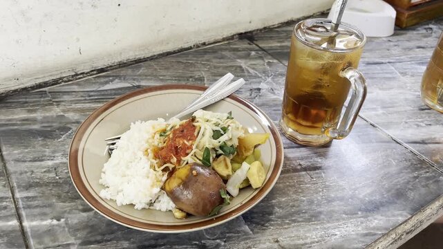 Traditional Indonesian rice rames dish served with sweet iced tea