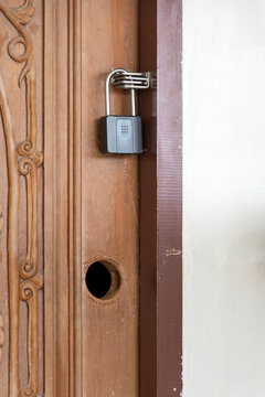 Key lock box attached to carved wooden door with missing doorknob for self check-in