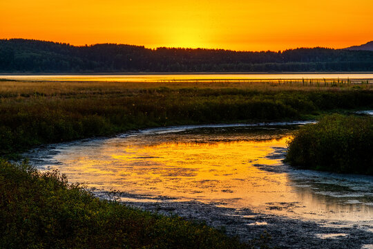 Magical Sunset over the lake with a beautiful reflection on the water. Serene lake in blue hour. Nature landscape