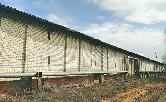 Industrial brick warehouse wall with utility pipelines
