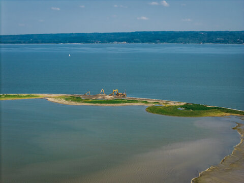 Aerial view of construction work on the Vistula Spit with excavators on the sandy shore surrounded by the Vistula Lagoon in Krynica Morska, Pomeranian Voivodeship, Poland.