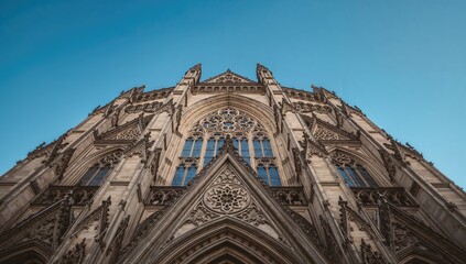 Fototapeta premium Gothic Cathedral Facade Reaching Skyward Against Clear Blue Sky