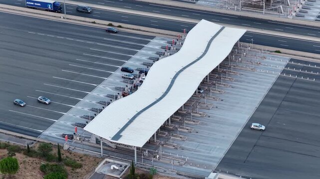 Baillargues, France &ndash; 18 July 2026: Top-down drone view of a motorway toll plaza with symmetrical traffic lanes and distinctive wave-shaped canopy in southern France.