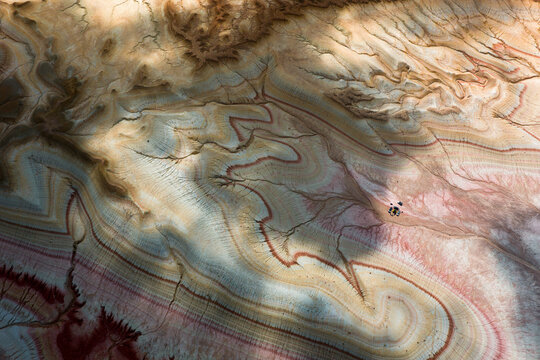 Aerial view of the colorful layered rock formations of Kyzyl Kup, known as Tiramisu, featuring intricate geological patterns and eroded slopes in Karakiya District, Mangystau Region, Kazakhstan.