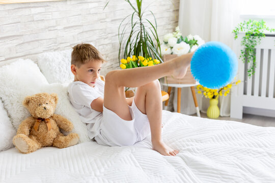 Cute little preschool child, cute blond boy, playing in bed with many teddy bears, handmade amigurumi toys, enjoying toy game