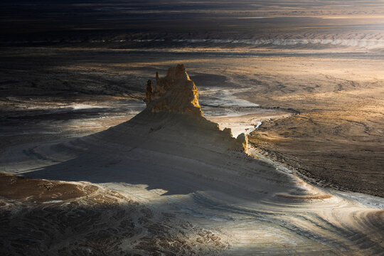 Aerial view of the dramatic limestone rock formations of Bozjyra, with rugged desert terrain, deep shadows, and vast arid landscapes, Aktau, Mangystau Region, Kazakhstan.