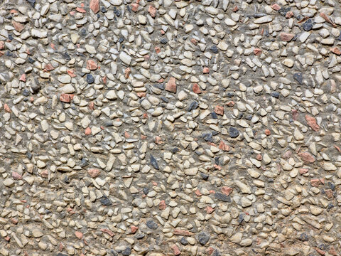 Pebble aggregate concrete wall texture background with small stones and speckled pattern