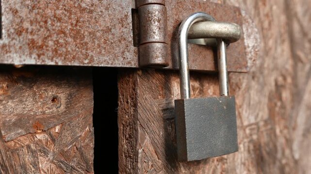 4K Padlock on Worn Plywood Door