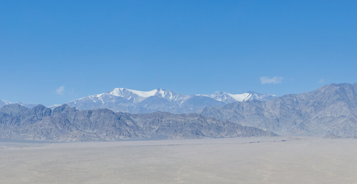 Vast Gobi Desert Plain And Snow Capped Mountains Under Clear Blue Sky
