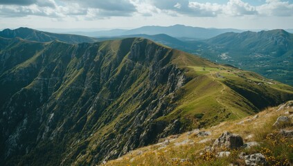 Fototapeta premium Mountain Ridge Overlooking a Valley Under Partly Cloudy Sky