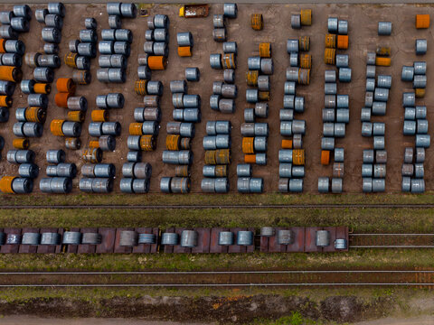 Aerial view of rows of steel coils stored at the Tata Steel facility, with a freight train loaded with metal coils on the tracks in Velsen-Noord, Noord-Holland, Netherlands.
