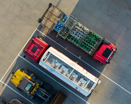 Aerial view of a red truck with gas cylinders, a white tanker truck, and a yellow construction vehicle parked at the GP Groot facility in Alkmaar, Noord-Holland, Netherlands.