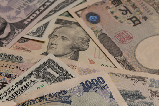 Japanese yen banknotes mixed with US dollar bills currency background