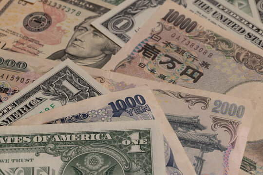 Japanese yen banknotes mixed with US dollar bills currency background