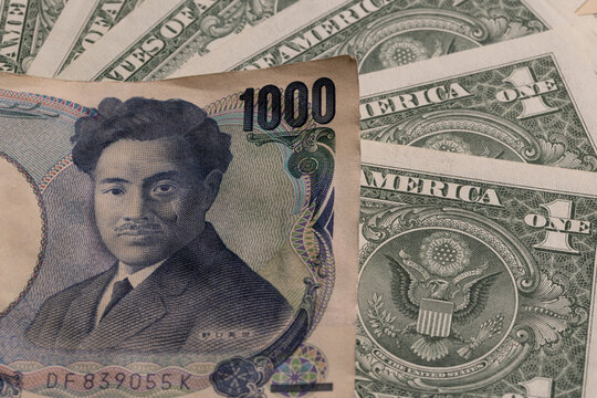 Japanese 1000 yen banknote over fanned US dollar bills background