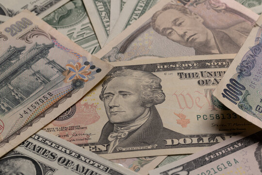Japanese yen banknotes mixed with US dollar bills currency background