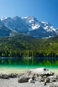 Travel landscape of Eibsee lake and Zugspitze mountains peak Alps in Bavaria, Germany, scenic summer nature panorama with forest and beach