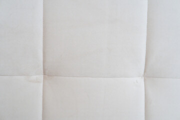 Fototapeta premium Close-up of a light cream tufted fabric upholstery texture with stitched square seams