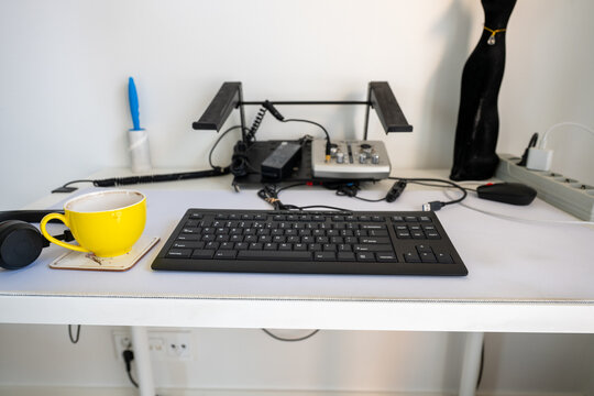 coffee cup on ergonomic office desk with keyboard headphone and modern workstation setup