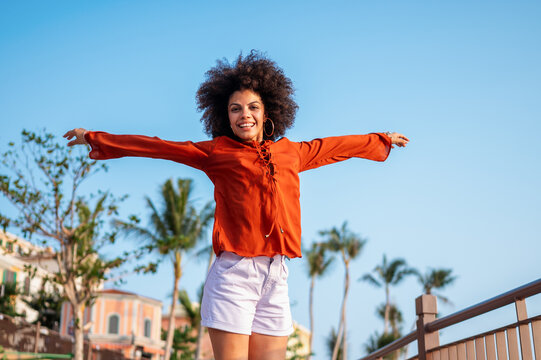 Capturing the expressive joy and vibrant outdoor lifestyle of a young woman celebrating a moment