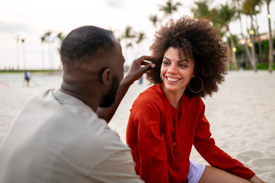 Romantic young couple embracing at sunset by the sea, sharing an intimate and joyful summer moment