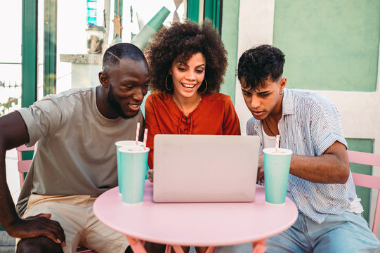 Friends bond through digital experiences, exploring content together on a laptop enjoying technology