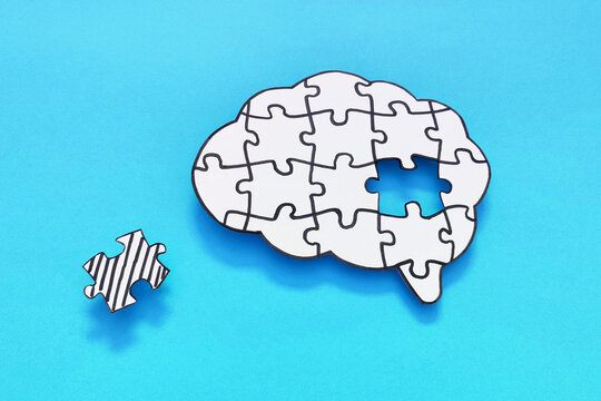 Mental health and problems with memory. Brain shaped jigsaw puzzle with missing piece on blue background.