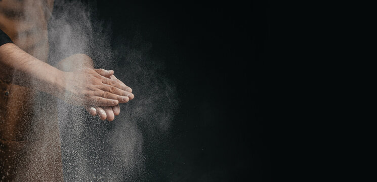 Baker Clapping Flour Covered Hands with Dramatic Powder Cloud