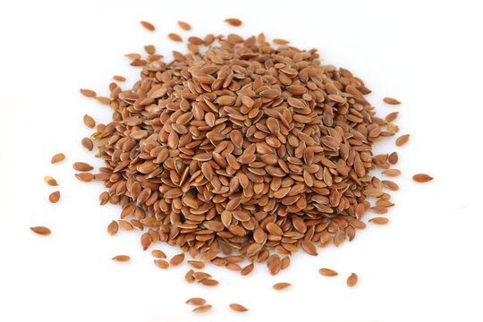 Flax seeds piled on a plain white background