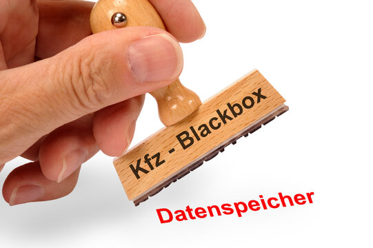 Eine Hand h&auml;lt einen Holzstempel mit der Aufschrift: Kfz - Blackbox und dem Abdruck Datenspeicher