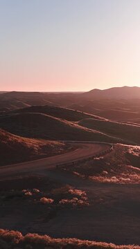 Dirt track through desert hills, Namibia. Aerial drone view of a winding road crossing the Sossusvlei highlands.