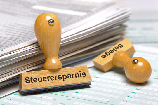 Ein Holzstempel ist bedruckt mit der Aufschrift: Steuerersparnis