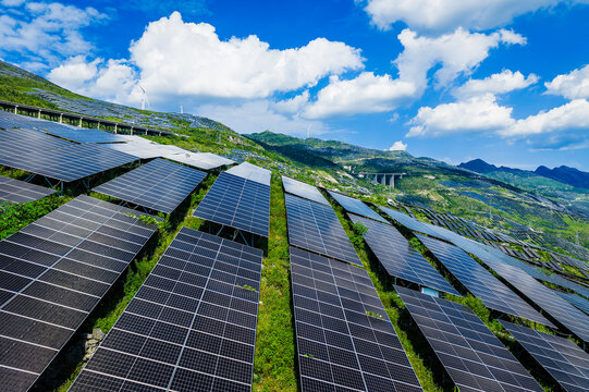 Aerial view of a large-scale solar farm with photovoltaic panels on green mountain slopes in Guizhou, China