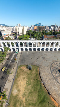 Aerial view of Arcos da Lapa featuring its iconic white arches, surrounding urban landscape, and paved plaza in Rio de Janeiro, Rio de Janeiro, Brazil.