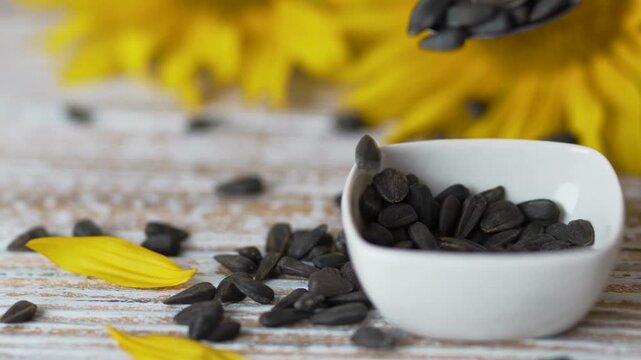 Closer view of sunflower seeds in white bowl with kitchen spoon video