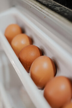 A neat arrangement of chicken eggs on the egg rack in the fridge
