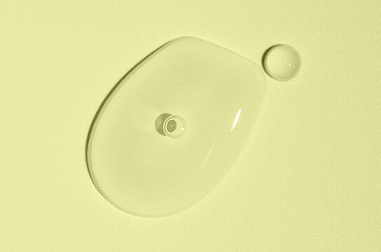 Cosmetic transparent product on a yellow background. A serum or gel or cream.