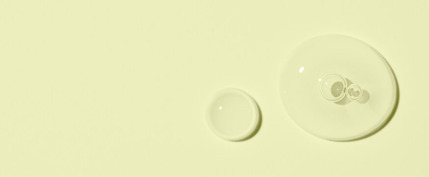 Cosmetic transparent product on a yellow background. A serum or gel or cream.