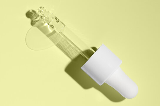 Cosmetic transparent product on a yellow background. A serum or gel or cream.
