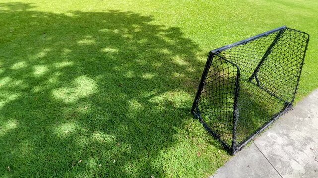 Mini soccer goal net on green grass field