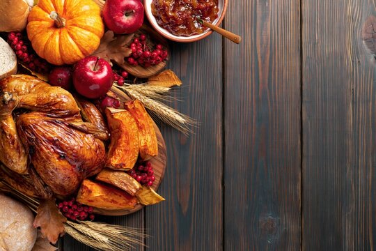 Thanksgiving Rustic Flat Lay with Roasted Turkey Pumpkin Apples Wheat and Copy Space on Dark Wooden Background