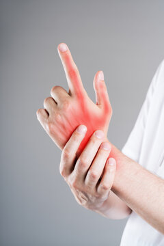 Close up of man massaging painful index finger with anatomical joint and red highlight. Arthritis, gout, trigger finger and bone inflammation concept