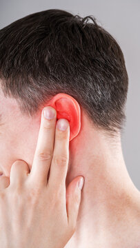Man with earache, ear pain and otitis, hearing impairment, painful area highlighted in red