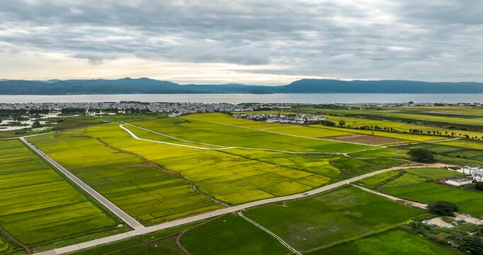 Aerial time‑lapse of Xizhou ancient town in Dali Yunnan, rice fields, villages and mountain landscape
